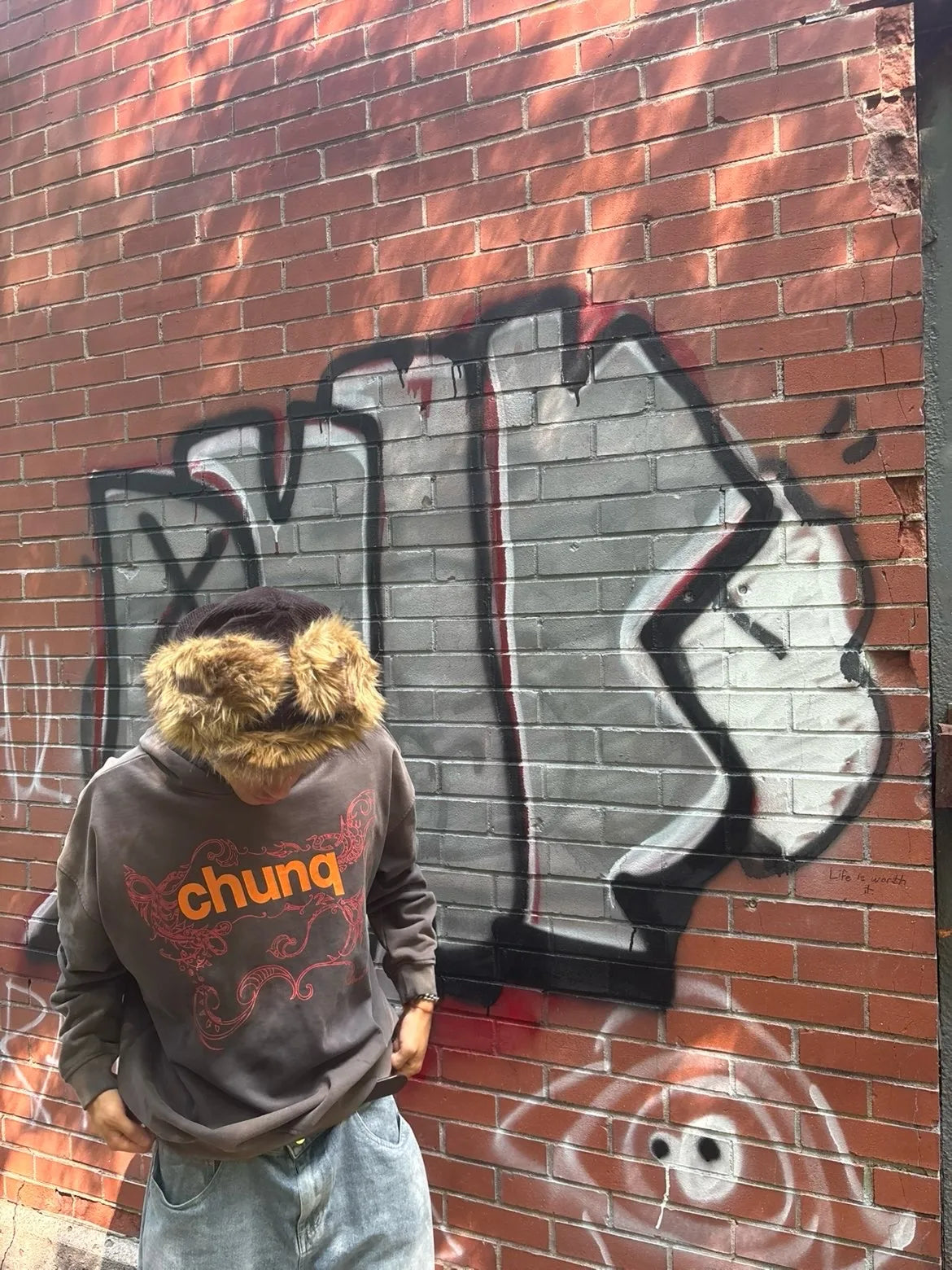 Model wearing a brown graphic Chunq hoodie by graffiti