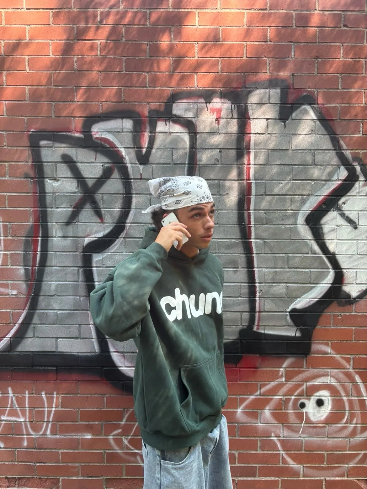 Side view of a green Chunq hoodie by graffiti